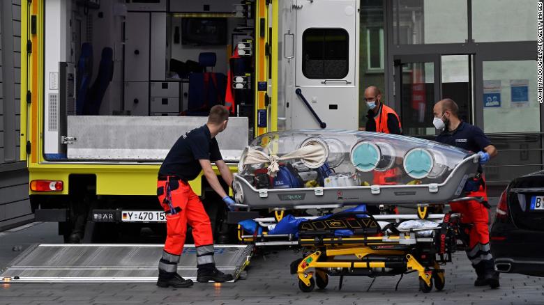 doctors loading epishuttle isolation unit into ambulance vehicle for transport of poisoned alexey navalny