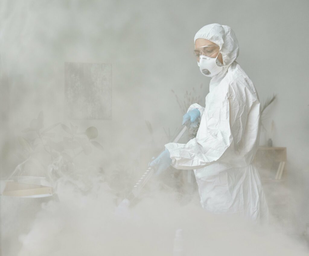 person in white ppe disinfecting the room