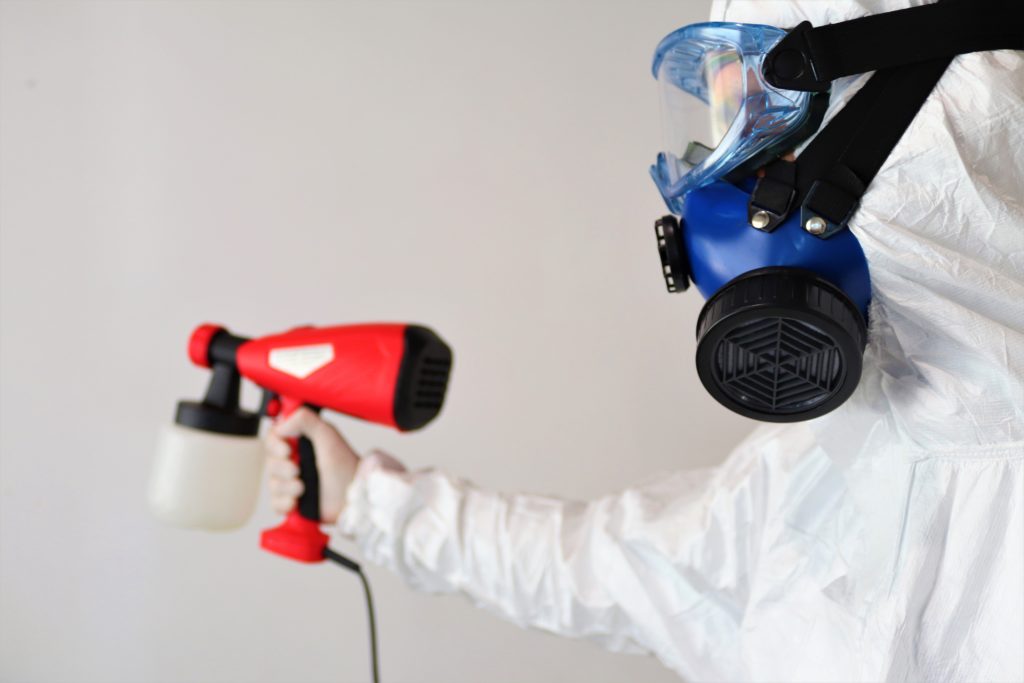 Man in PPE spraing disinfectant