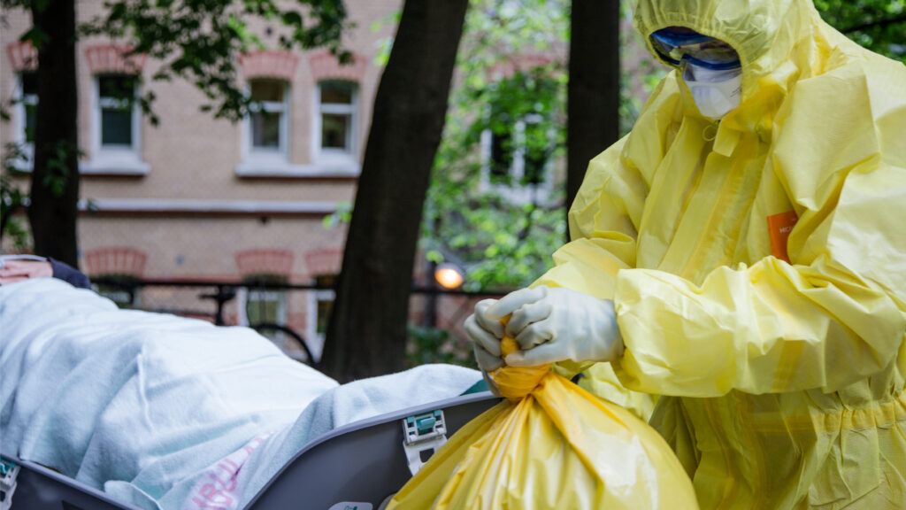 doctor in PPE tossing chemical biological waste